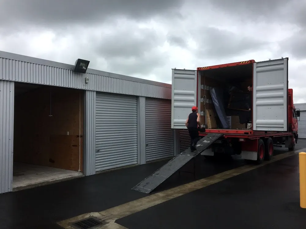 A truck unloading at an open storage unit